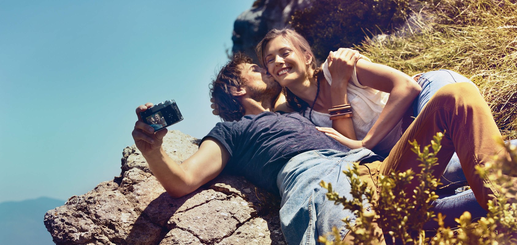happy couple on the edge of the cliff taking a selfie