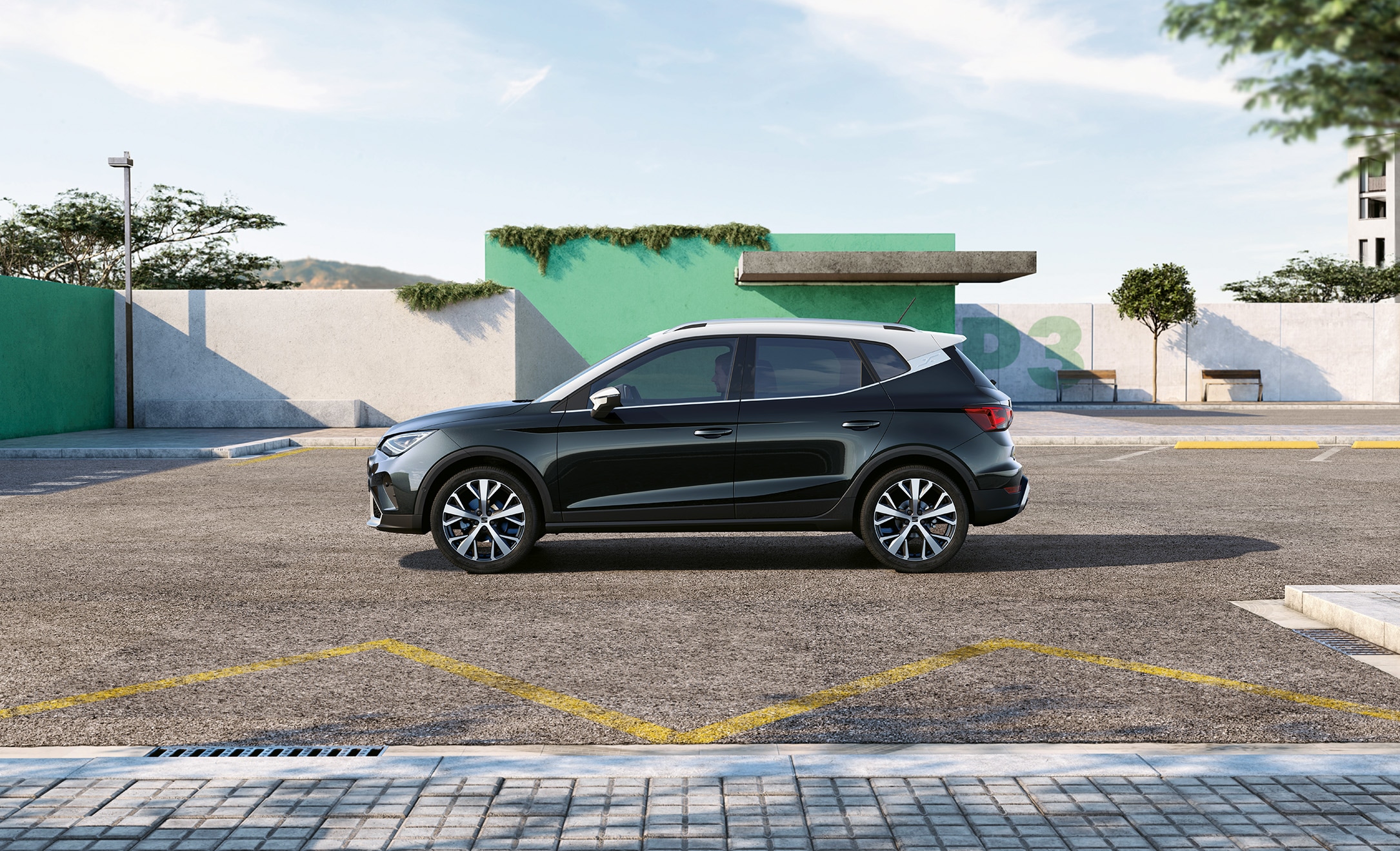 side view of a black SEAT Arona parked outside near a green wall