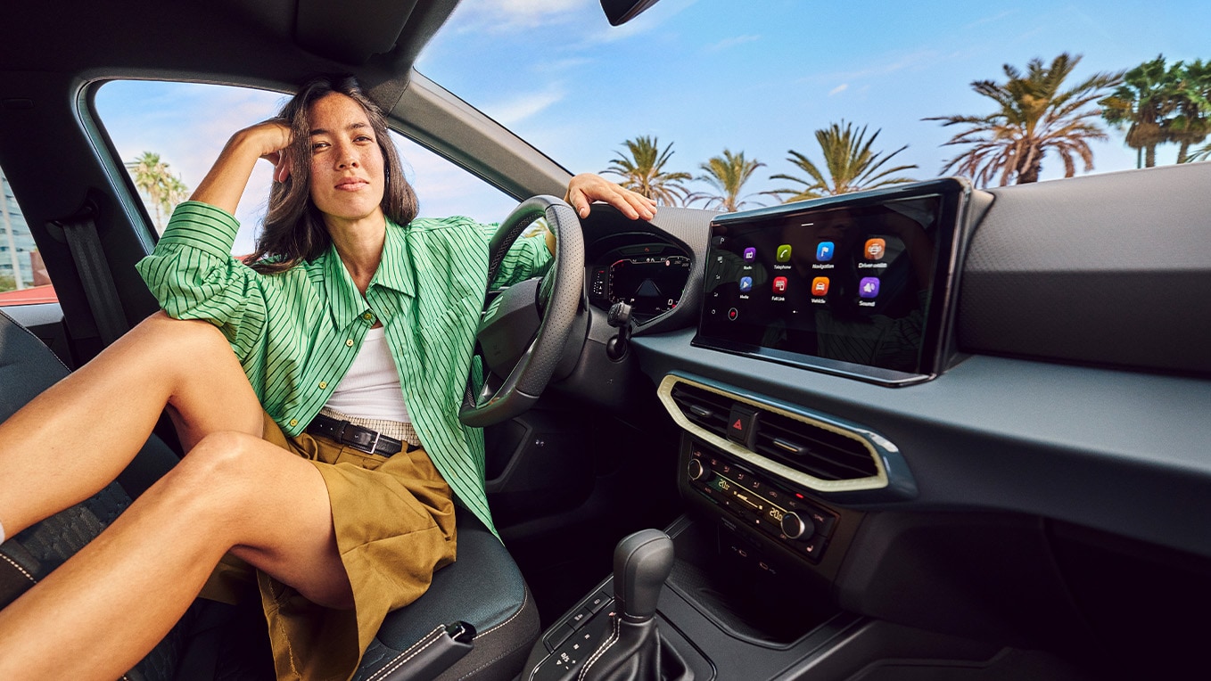 Interior view of SEAT Arona showing THE advanced navi system, with a 9.2” screen and stylish urban setting outside.