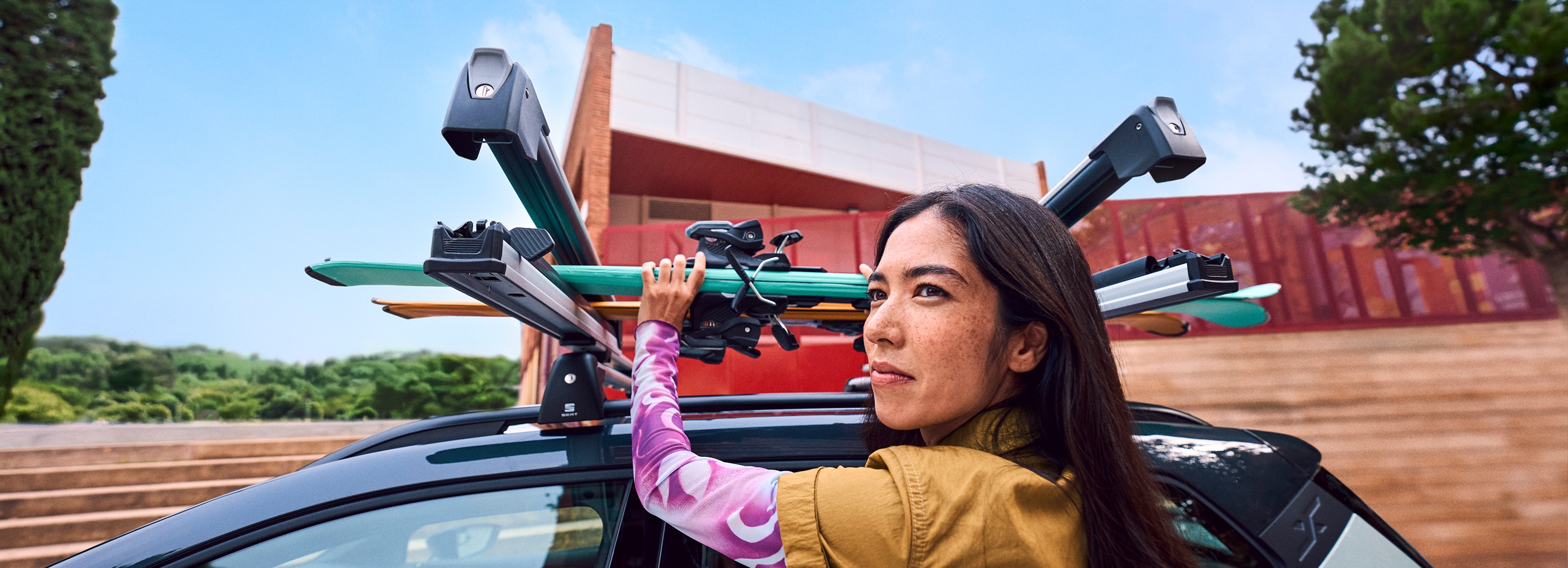 SEAT Arona equipped with ski rack carrying skis outdoors.