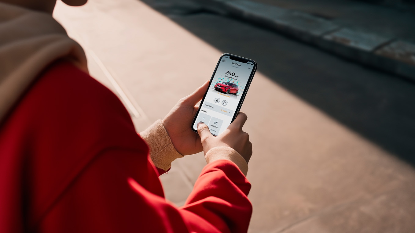 A person holding their smartphone with the SEAT Connect app on the screen