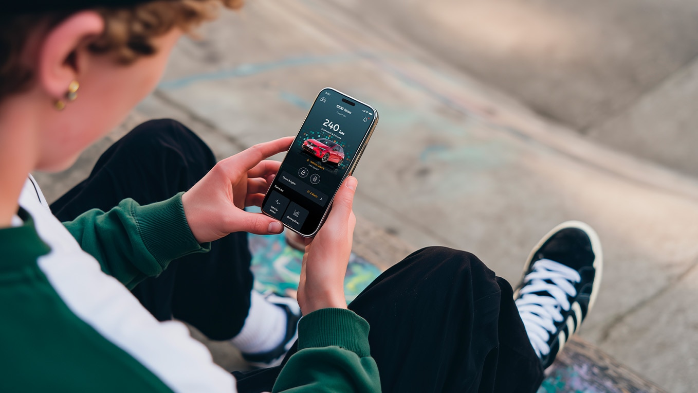 Person holding their smartphone using seat’s remote functions