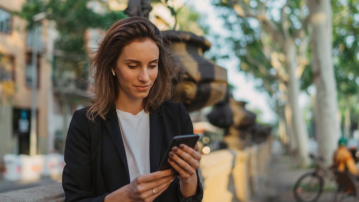 Woman holding her cell phone connected to the SEAT CONNECT app.