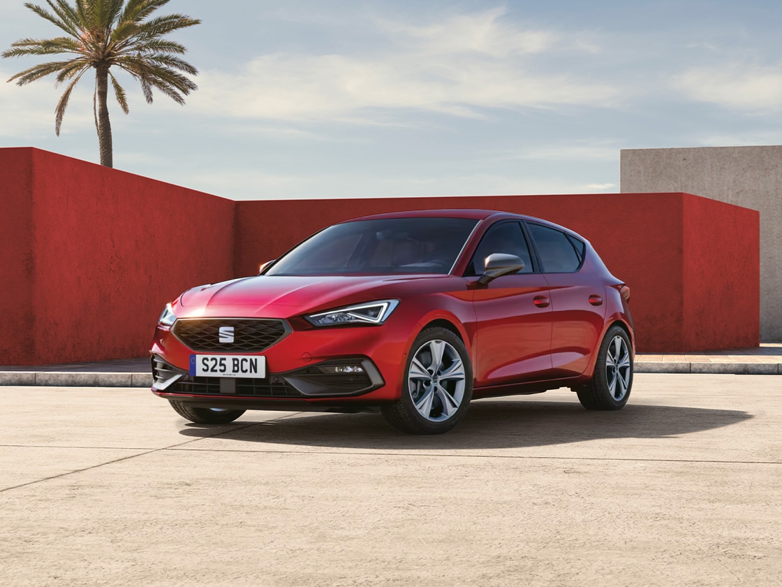 a red SEAT Leon FR parked on a paved road
