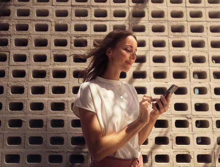 A woman looking at her phone using SEAT Connect
