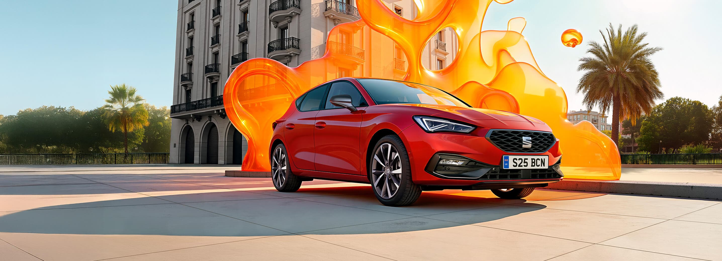 A red SEAT Leon with a large yellow flame styled structure in the background