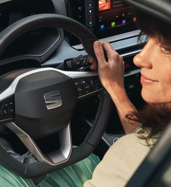 Inside view of a SEAT car with a person holding the steering wheel