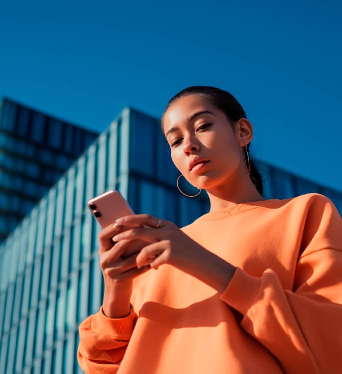 A woman holding and using a mobile phone