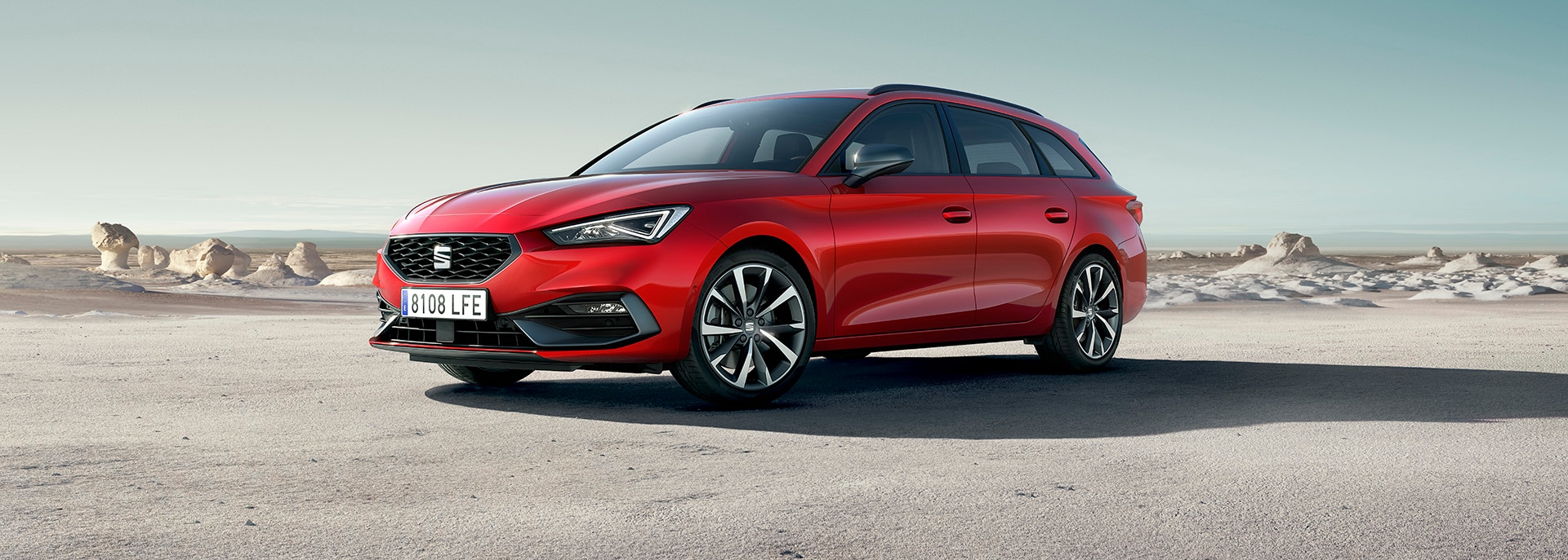 A woman walking towards a SEAT Arona parked on gravel