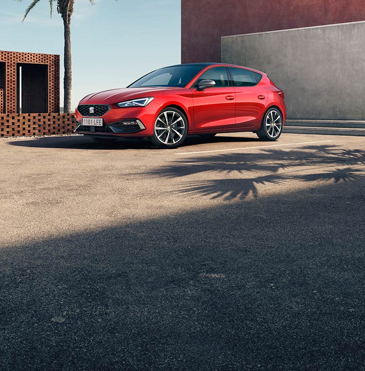 A red SEAT Leon with surrounded by concrete walls