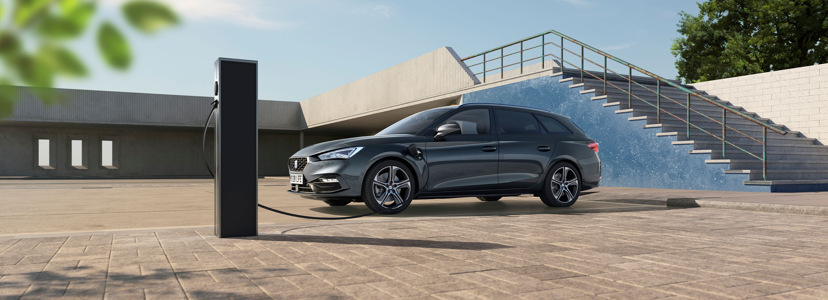Side view of a SEAT’s plug-in hybrid car in red, parked and charging in a semi-outdoor and partially sunny spot, highlighting the idea of being able to drive efficiently while respecting the environment, reducing emissions.